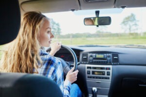 young confident woman driving a car