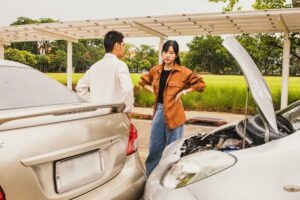 Angry woman quarrels with man who drives car in front of him suddenly causing an accident on the road that drives private car illegally causing damage, requiring insurance liability.