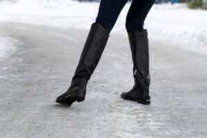 Woman slips on slippery road covered with ice. Concept of injury risk in winter.