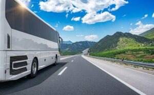 White passenger bus on the highway against the backdrop of a beautiful landscape.