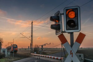 A railroad crossing in a landscape with a train